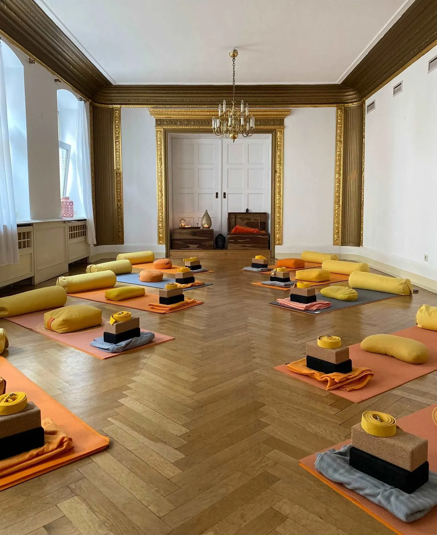 Yogaraum mit Fischgrätparkett und vorbereiteten Matten
